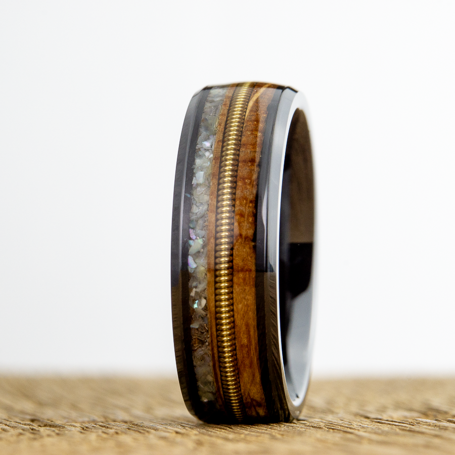 black ring with whiskey barrel wood , guitar string and mother of pearl